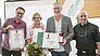 Patrick Rittich (Creditplus, li.) hielt die Laudatio auf den diesjährigen Drittplatzierten, das Fahrzeug-Center Schriewer, und überreichte Dagmar Calmer und Siegfried Schriewer-Calmer einen Scheck über die von Creditplus spendierte Siegprämie von 1.000 Euro. World of Bike-Verleger Klaus Hüttinger (re.o.) steuerte Pokal und Urkunde bei.